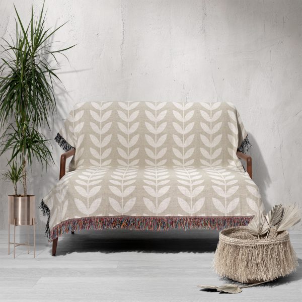 Scandinavian Minimalist Leaf Woven Blanket draped over a sofa in a minimalist room.