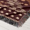 Detailed view of the tribal-patterned woven blanket, highlighting the intricate tribal motifs.