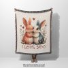 An Adorable Bunny Love woven blanket, held up by an unseen person