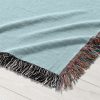 A close-up view of the woven blanket showing intricate butterfly and heart designs.