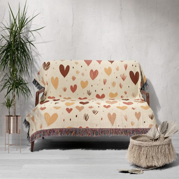 The Enchanted Hearts Woven Blanket draped over a sofa, adding a cozy yet elegant touch.