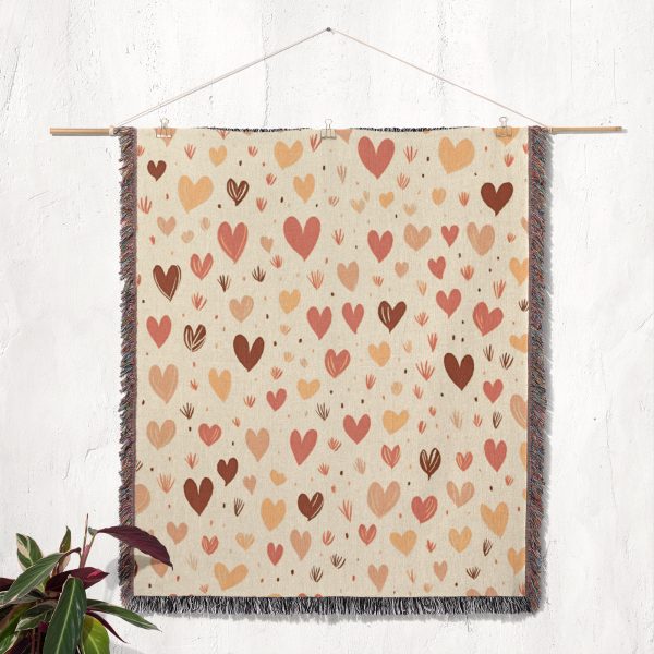 The Enchanted Hearts Woven Blanket hanging on a wall as a tapestry, showcasing its timeless design.