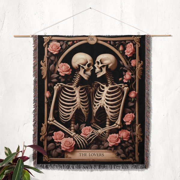 The woven blanket with a skeleton couple design displayed as a wall tapestry.