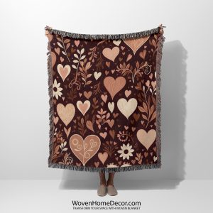 A Floral and Heart Dark woven blanket, held up by an unseen person