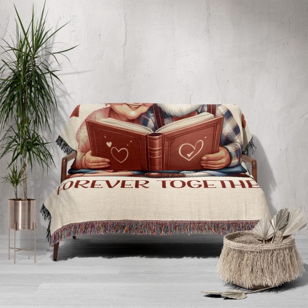 The woven blanket with an elderly couple design draped over a sofa.