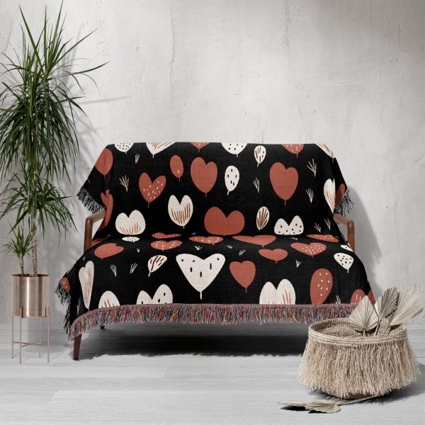 The Heart Pattern Woven Blanket neatly draped over a sofa, adding a pop of color to the room.