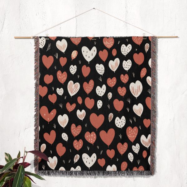 The Heart Pattern Woven Blanket displayed as a tapestry, hanging on a wall for decorative purposes.