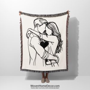 A Minimalist Love Embrace woven blanket held up by an unseen person.