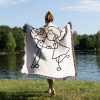 A person standing by a lake, wrapped in the Minimalist Love Sketch blanket, view from behind