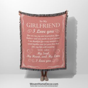 A woman holds the Romantic Girlfriend Woven Blanket, displaying its loving words and intricate borders.