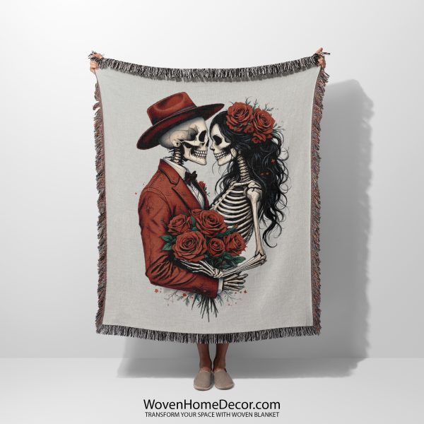 A Romantic Skeleton Couple woven blanket, held up by an unseen person