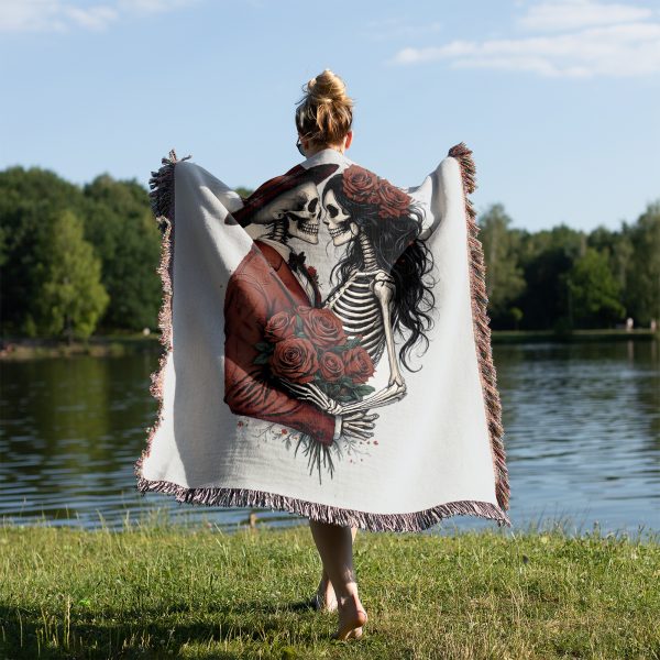 A person standing by a lake, wrapped in the Romantic Skeleton Couple blanket, view from behind