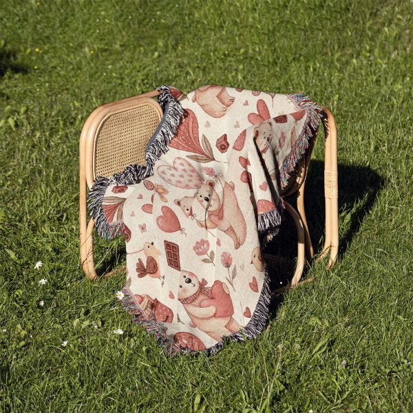 The Whimsical Bear and Balloon Love blanket resting on a chair outdoors on a grassy lawn