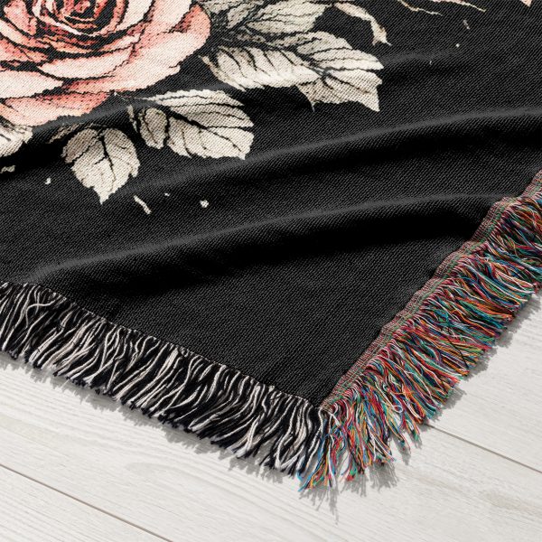 A close-up view of the woven blanket showing the skeleton skulls and detailed roses.