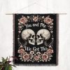 The woven blanket featuring skeleton skulls displayed as a wall tapestry.